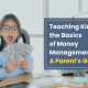 Child holding money fanned out while sitting in a chair at a desk with the blog title in a box to the side